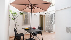 A patio with a table, chairs, a table umbrella, and a potted plant. - Secret House by Wonderful Italy (Bari)