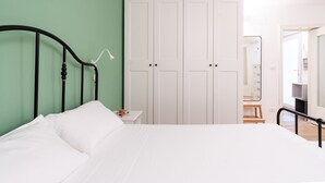 A bedroom with a bed, a nightstand, a white wardrobe, and a mirror. - Secret House by Wonderful Italy (Bari)