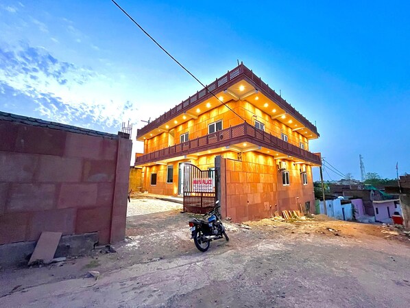 A two-story building with a gated entrance and a motorcycle parked in front.