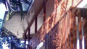 A wooden balcony with intricate railings and a view of the sky. - Roatan Airport Boutique Resort (Coxen Hole)