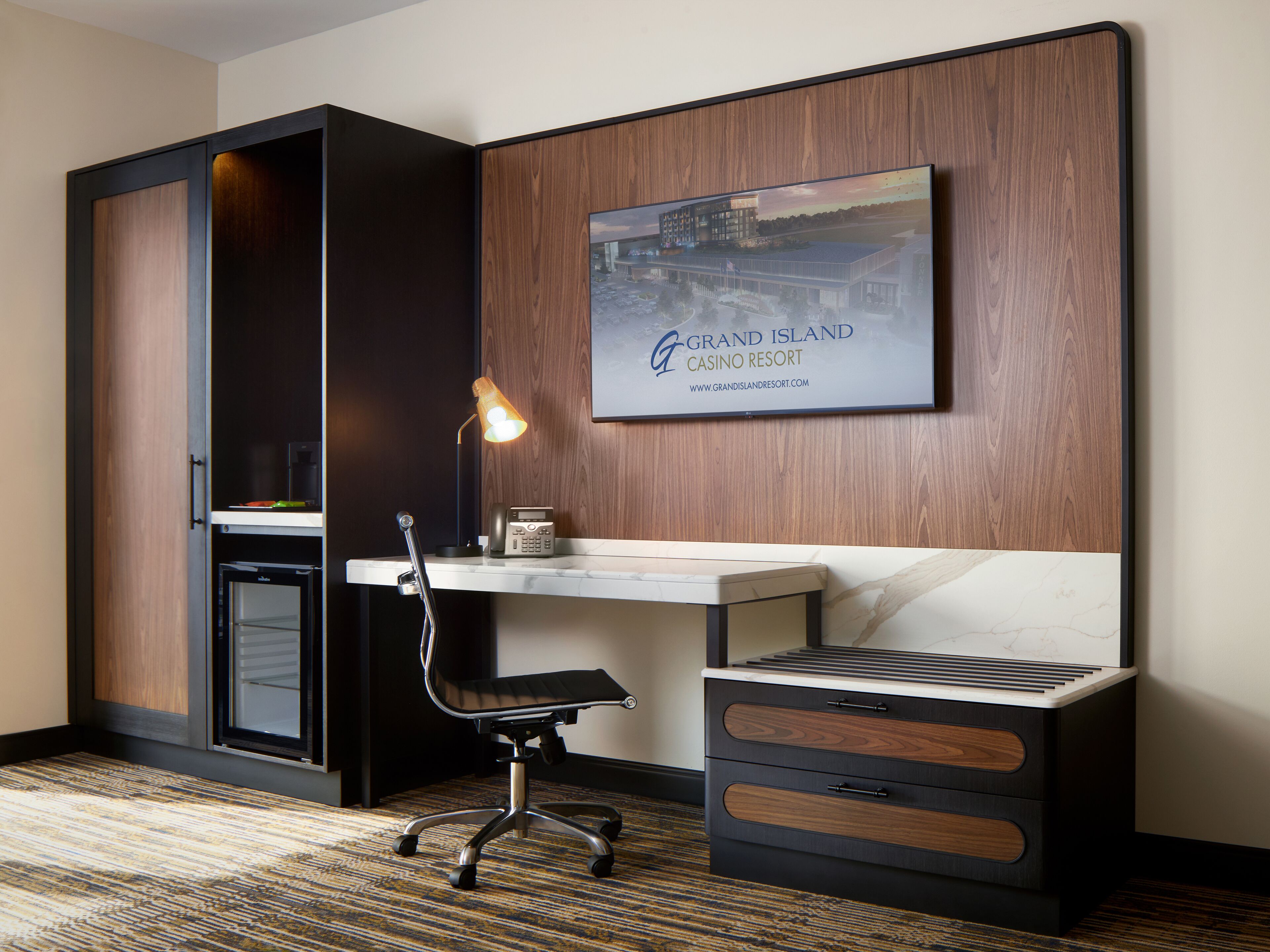 Une chambre d’hôtel équipée d’un bureau, d’une chaise et d’un tableau représentant un centre de villégiature.