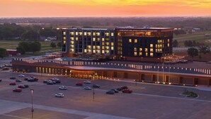 Un hôtel moderne doté d’une entrée imposante, d’un parking et offrant une vue sur le paysage environnant.
