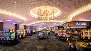 Un casino avec des machines à sous, une table de blackjack et un bar.