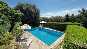 A rectangular swimming pool with a tiled deck, surrounded by lush greenery and trees. - Le SIG - Swimming pool - 6 rooms (Piolenc)