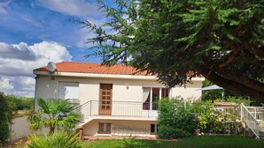 A two-story house with a red-tiled roof, a balcony, and a well-maintained lawn. - Family home between sea and countryside for 6 people (aubigny)