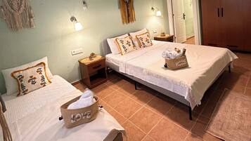 Un dormitorio con dos camas, un armario, aire acondicionado y una mesita de noche con lámpara.