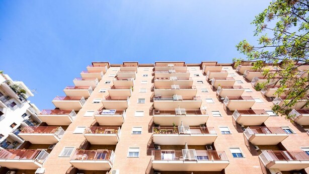 A multi-story hotel with balconies, air conditioning units, and a clear blue sky. - Palermo | Calatafimi House (Palermo)