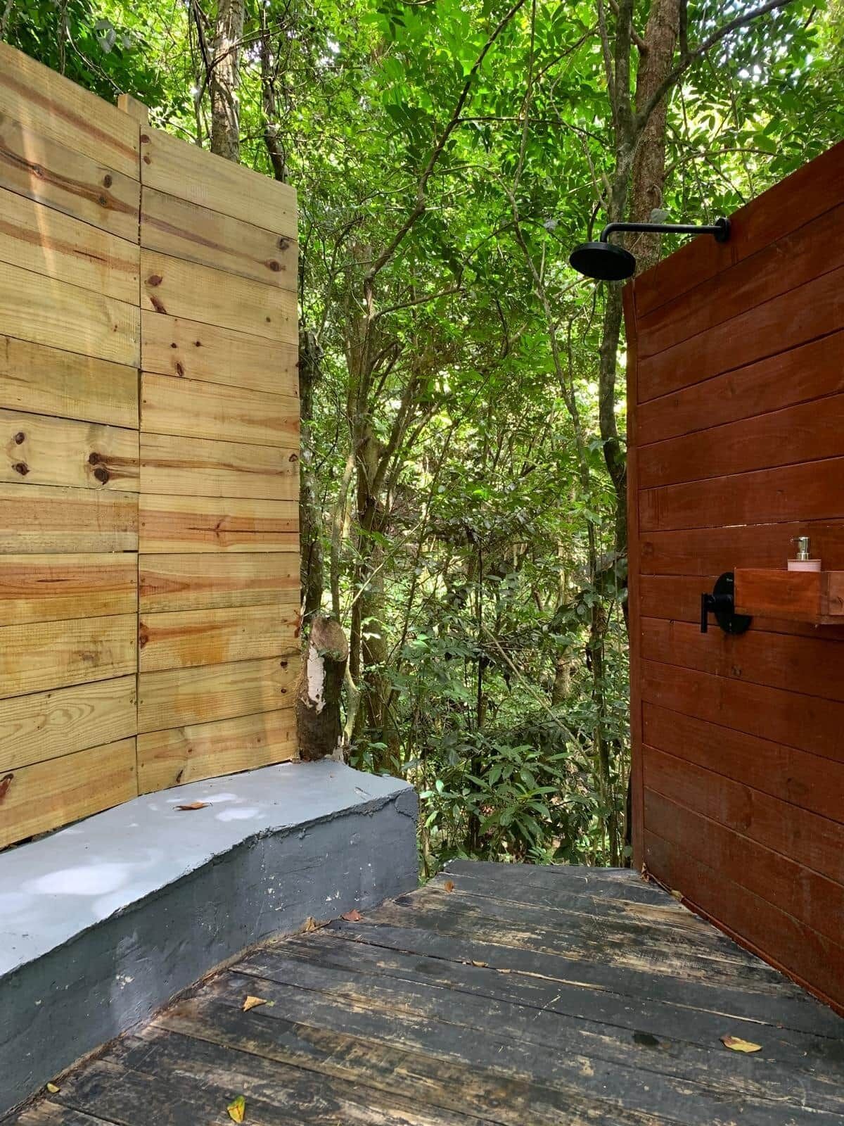 A wooden spa area with a shower and a small sink.
