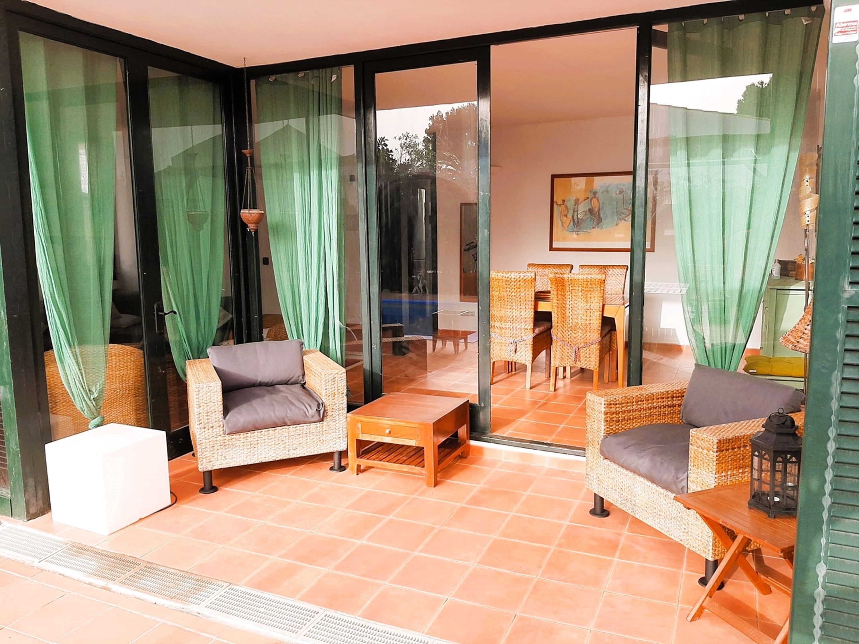 A room with wicker furniture, a small table, and a chair.