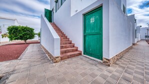 Un edificio moderno con una puerta verde que lleva el número 23 y una escalera que conduce a la entrada.