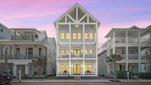 A multi-story beachfront hotel with balconies, a central entrance, and a well-maintained garden. - Coral Kingdom 413 COA (Port Aransas)