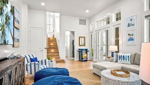 A spacious living room with a staircase, a sofa set, and a coffee table. - Pelican Place 108 RET (Port Aransas)