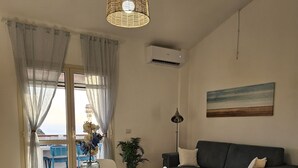 A dining area with a round table, chairs, and a hanging light fixture. - Apartment with sea-view terrace for breathtaking sunsets. (Nebida)
