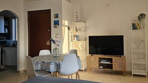 A modern bedroom with a bed, a TV, a dining table, and a kitchen area. - Apartment with sea-view terrace for breathtaking sunsets. (Nebida)