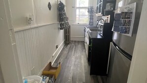 Eine Küche mit Kühlschrank, Spüle und Holzboden.