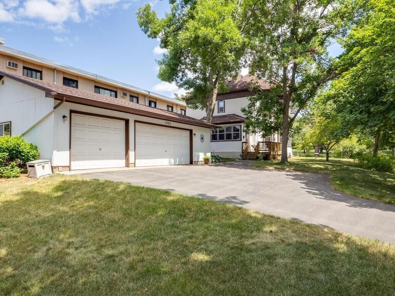 A two-story house with a garage and a covered porch.