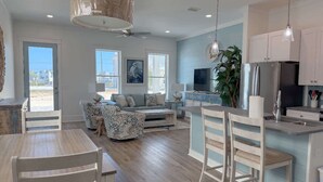 A spacious living area with a sofa, a dining table, and a kitchen with a large island.