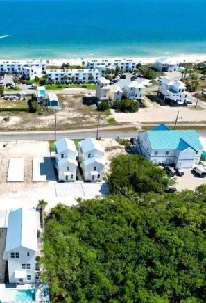 A coastal resort with multiple white buildings, a beach, and a swimming pool. - A Serenity by the Sea St George Island Pool Home (Eastpoint)