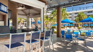 A poolside area with bar seating, umbrellas, and lounge chairs. - Marina Access | Golf. Outdoor Pool. Gym. (Stuart)