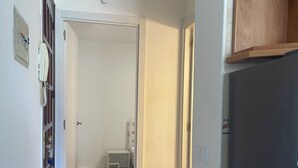 A hallway with a tiled floor, a wooden cabinet, and a refrigerator. - Apartment in Salou near the beach 10 min drive from Portaventura (Salou)