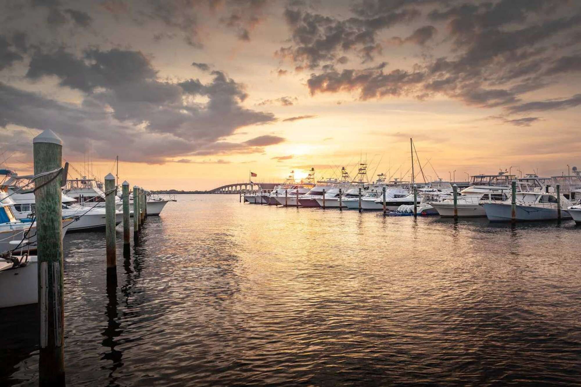A marina with boats docked under a sunset sky.