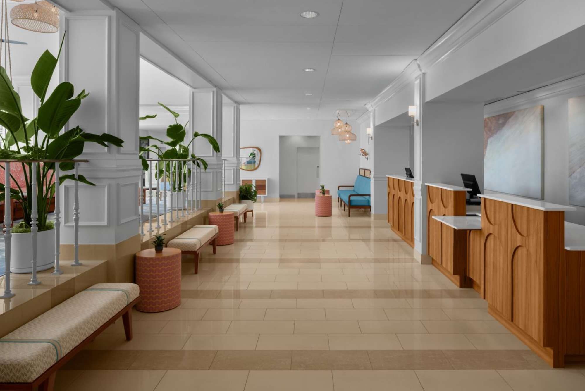 A hotel lobby with a reception desk, seating area, and large windows.