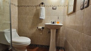 A bathroom with a toilet, sink, and mirror.