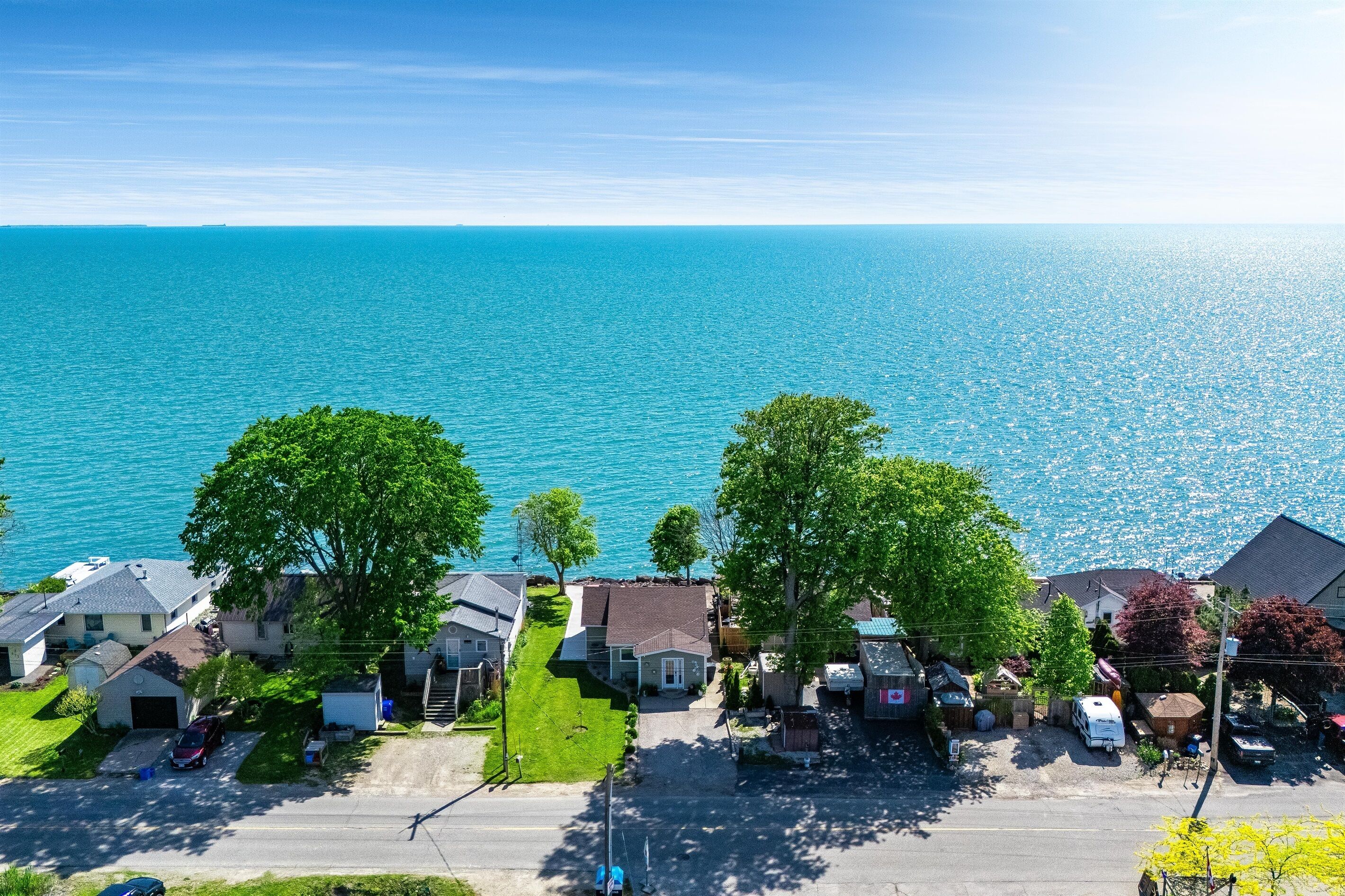 A residential area with houses, a road, and a view of the ocean.