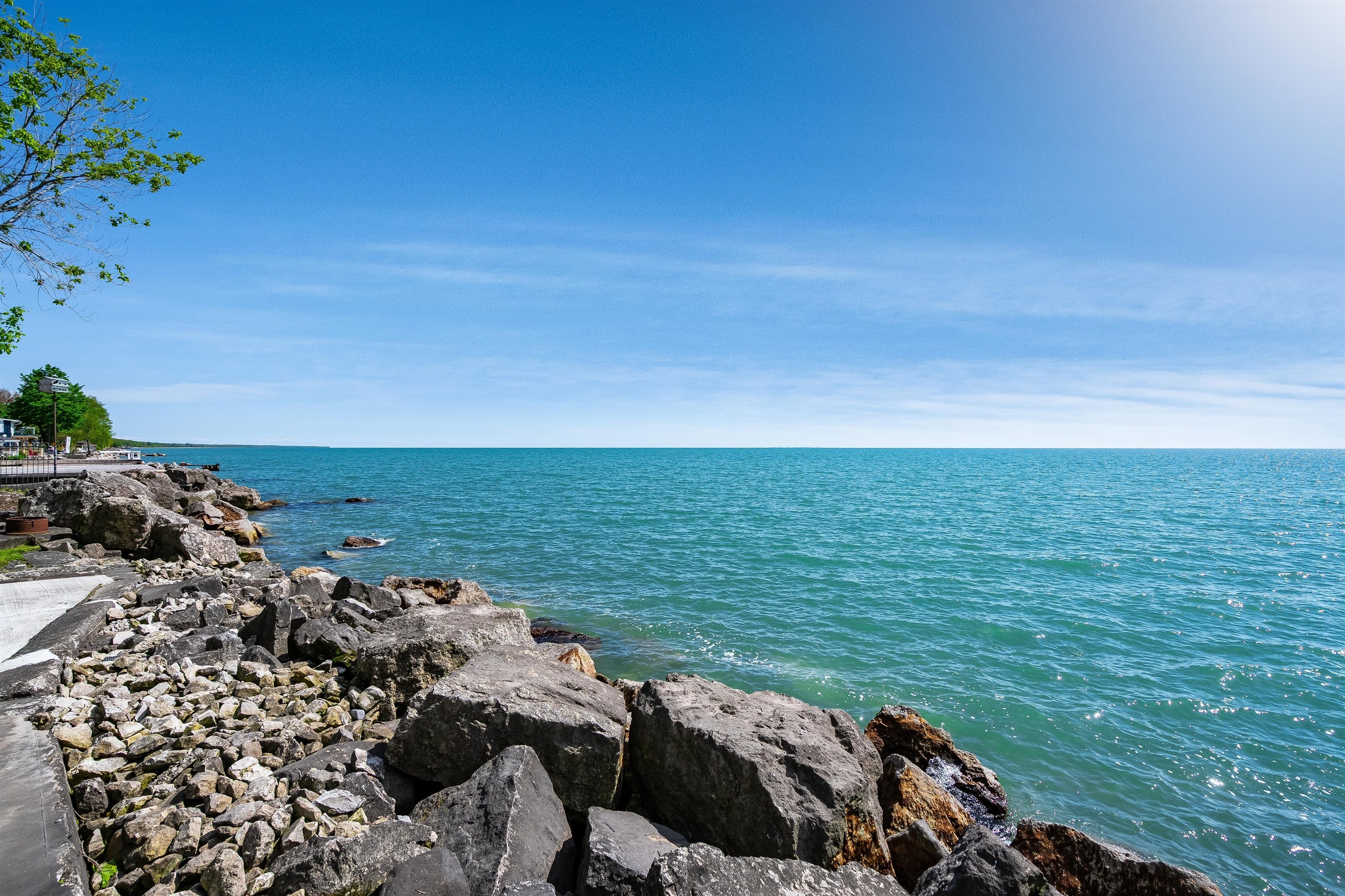 Eine felsige Küstenlinie mit klarem, blauem Wasser und ein Gebäude in der Ferne.