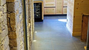 A corridor with stone walls, a tiled floor, and recessed lighting. - CHALET MAÉ (Risoul)
