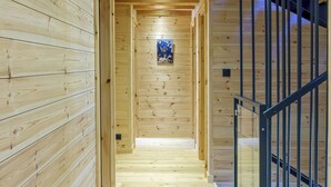A wooden interior hallway with a staircase on the right. - CHALET MAÉ (Risoul)