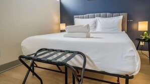 Ein Hotelzimmer mit einem Bett, einem Nachttisch mit Lampe und einem Wandbild.