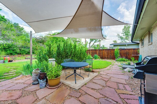 A patio with a table and chairs, a grill, and a large umbrella providing shade. - < 1 Mi to CU Boulder: Home w/ Fenced Yard! (Boulder)