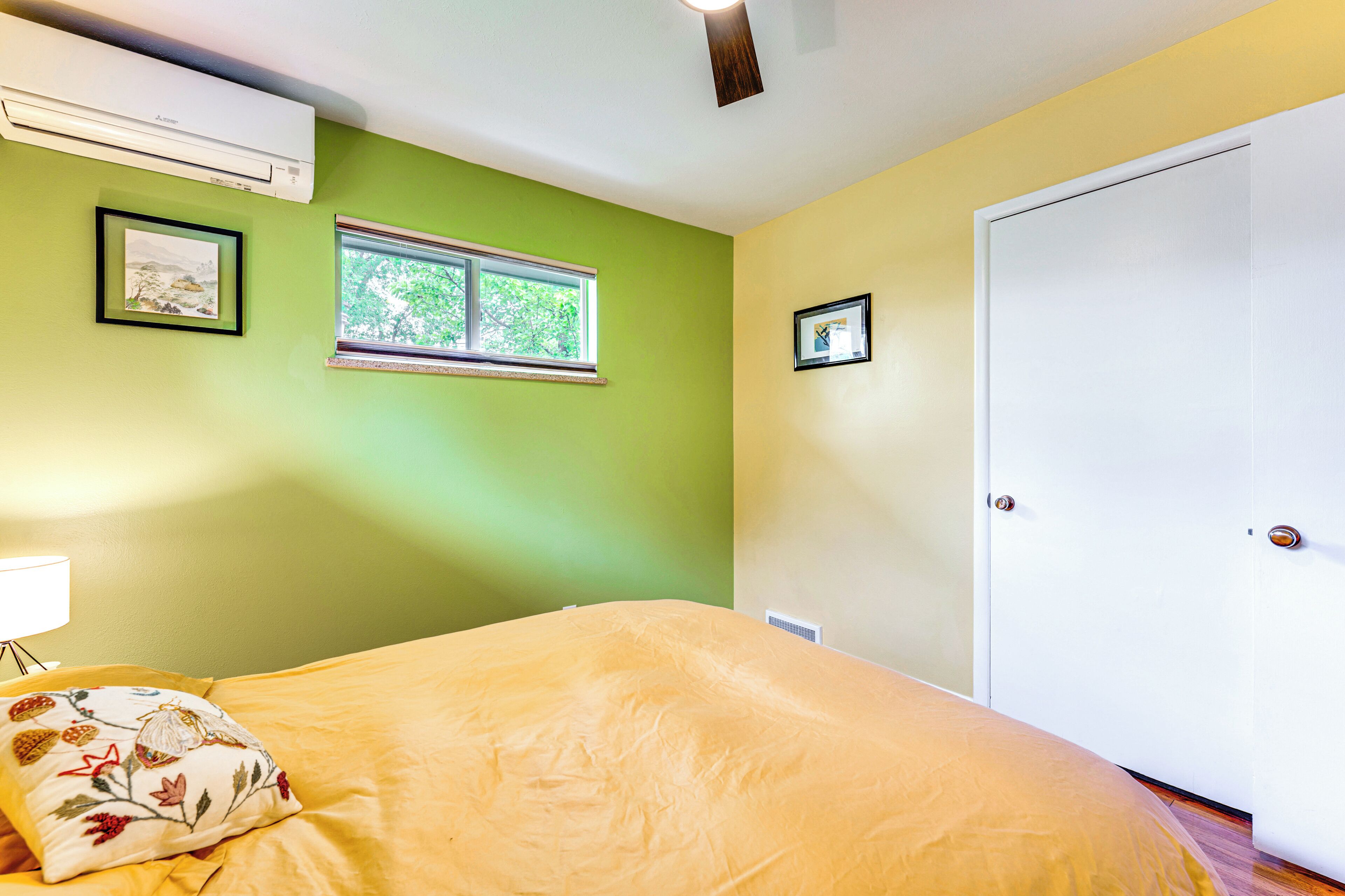 A bedroom with a bed, a window, and a door.