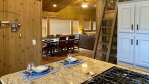 A kitchen with a granite countertop, white cabinets, and a gas stove.