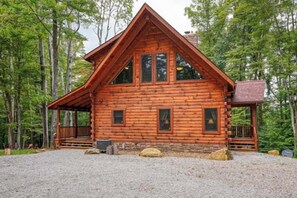 Eine Blockhütte mit Veranda, umgeben von Bäumen.