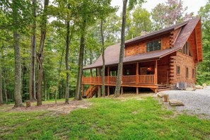 A log cabin with a porch, surrounded by trees. - Bear Pines charming 3 bdrm cabin, Hot Tub, WiFi, in scenic South Bloomingville (South Bloomingville)