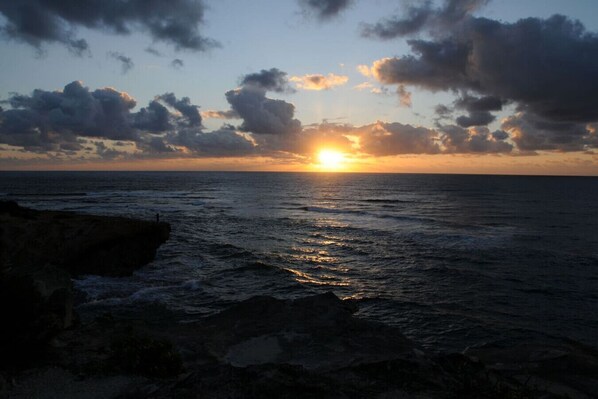 A sunset over the ocean with a rocky shoreline. - Luxe Oceanview Getaway w/ Heated Pool & Epic Sunrise (As Seen on TV) (Koloa)