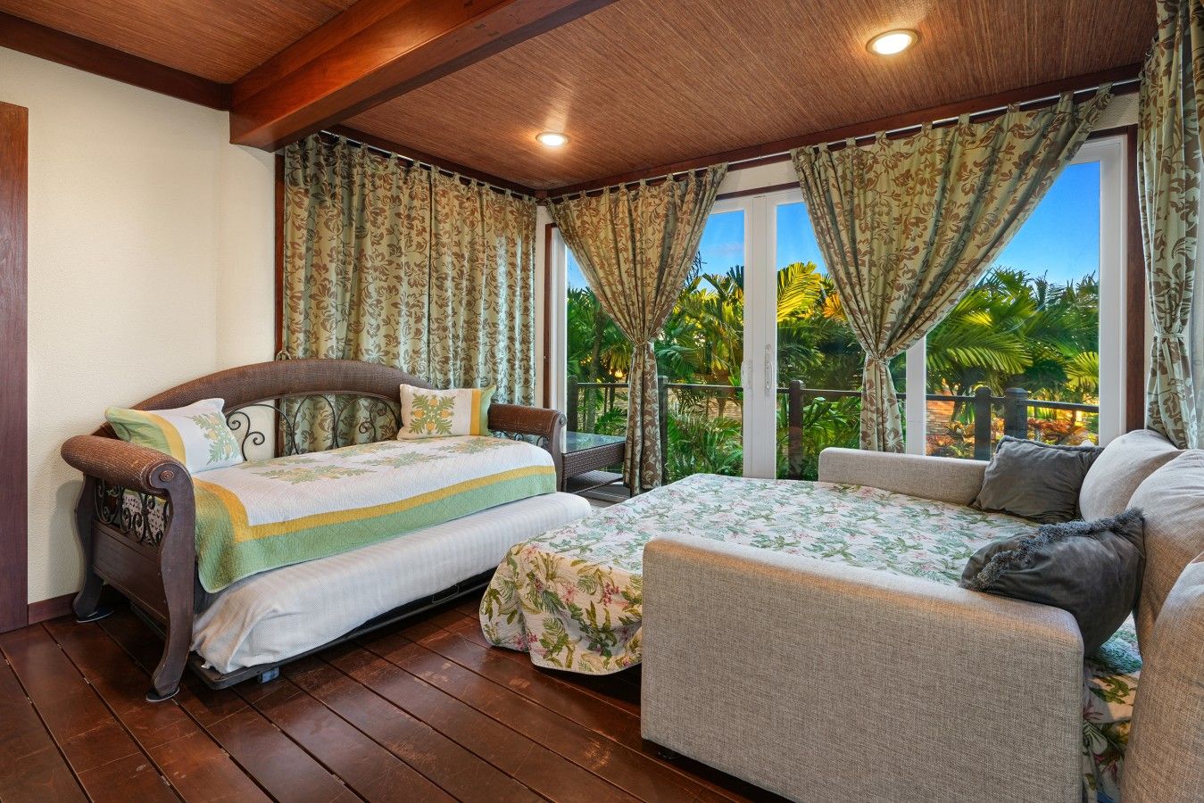 A bedroom with a bed, a sofa, and a window with curtains.