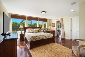 A bedroom with a large bed, a desk, a chair, and a TV. - Luxe Oceanview Getaway w/ Heated Pool & Epic Sunrise (As Seen on TV) (Koloa)