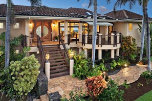 A two-story house with a covered porch, a staircase, and a landscaped garden. - Luxe Oceanview Getaway w/ Heated Pool & Epic Sunrise (As Seen on TV) (Koloa)