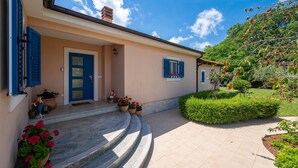 A house with a blue door, a small porch with steps, and potted plants. - Amazing home in Svetvincenat with WiFi (Svetvincenat)