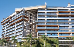 A multi-story hotel with balconies, large windows, and a modern architectural design.