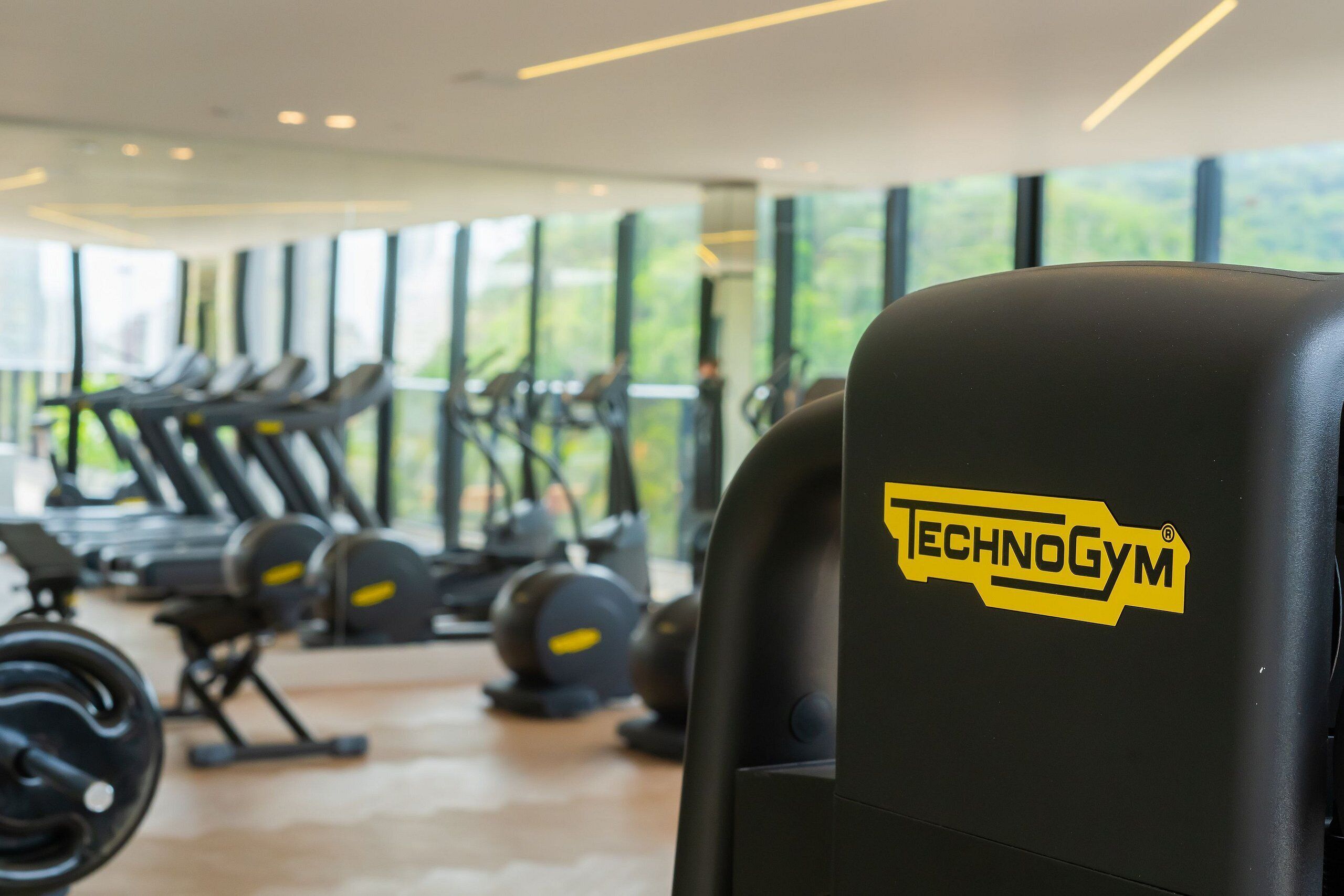 Un gimnasio con equipamiento cardiovascular y el logotipo de Technogym.