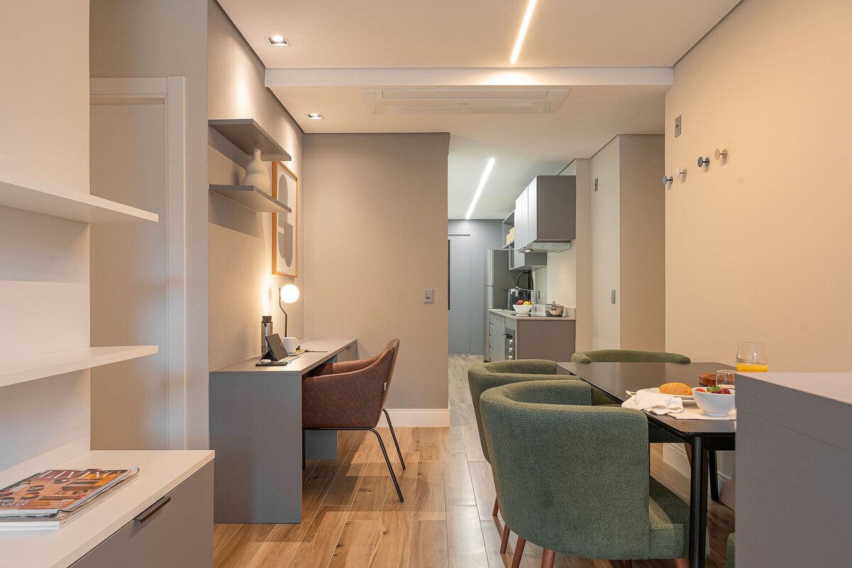 Una cocina moderna con comedor, suelo de madera y una pequeña mesa con sillas.