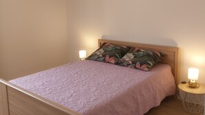 A neatly made bed with a pink quilt, two bedside lamps, and a patterned pillow. - Gite Detached house sleeps 6 Pets welcome Wifi lake 10mn (Lacapelle-Viescamp)
