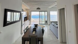 Une cuisine moderne avec un coin repas, de grandes fenêtres et une vue sur la mer.
