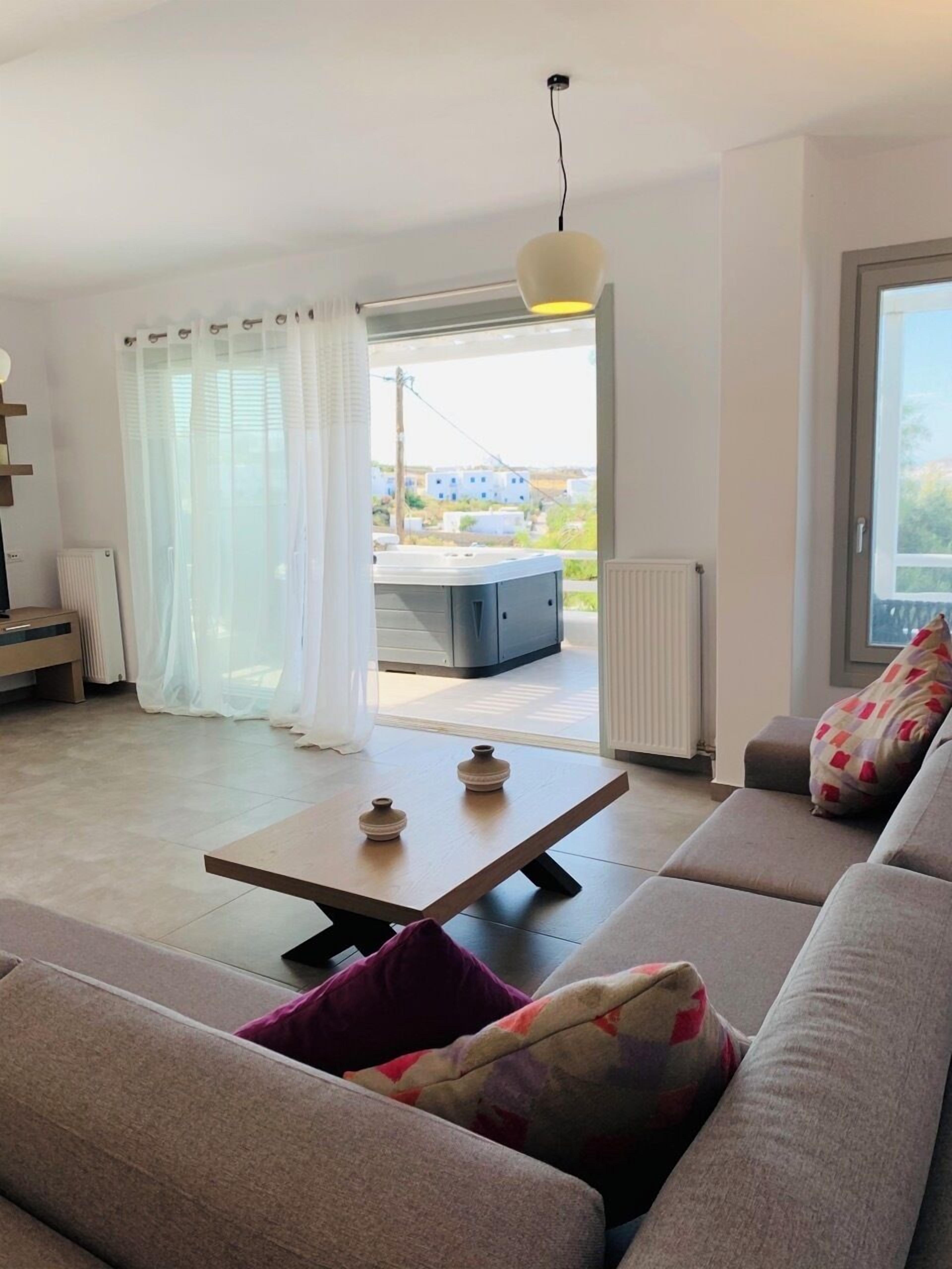 A modern living room with a sofa, a coffee table, and a view of the outside.