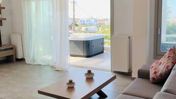 A modern living room with a sofa, a coffee table, and a view of the outside.