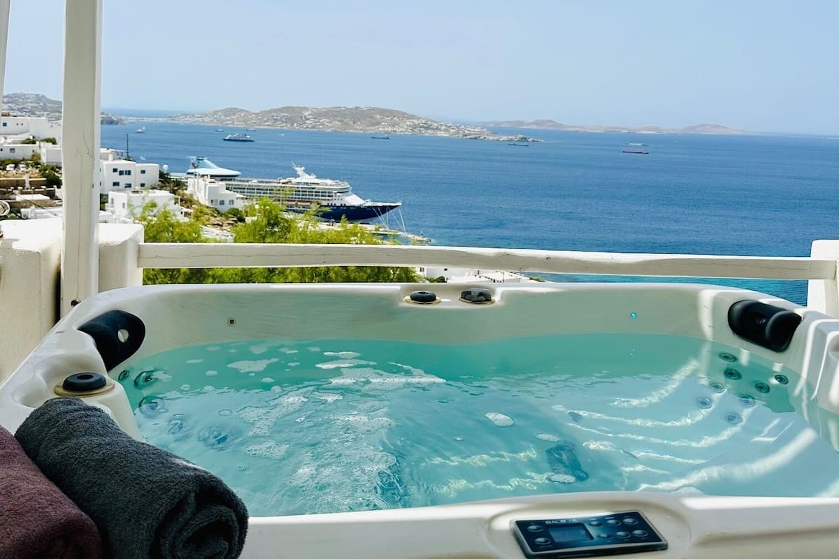 A hot tub with a clear view of the sea and distant land.